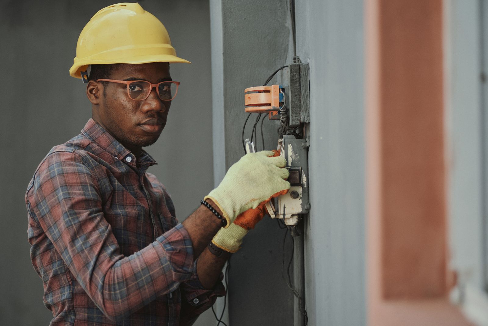 A tradesman carefully working on a minor electrical repair on a wall fixture